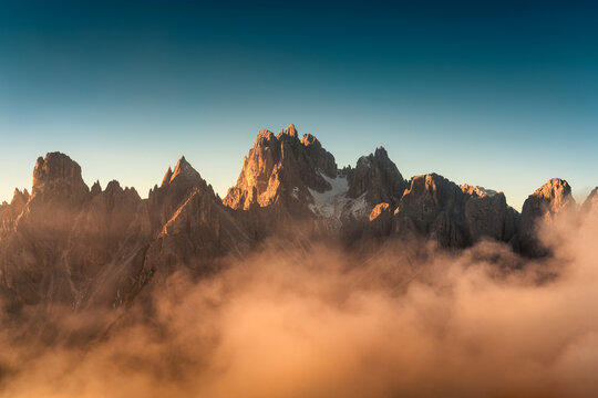 Sunrise shining on Cadini di Misurina peaks and foggy in Dolomites, Italy