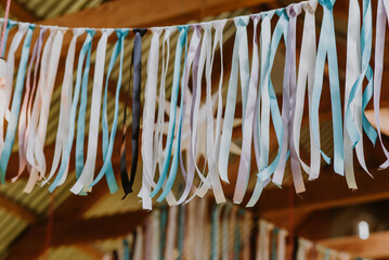 ribbons hang from a barn roof as party decorations in pink and blue © zoerae28