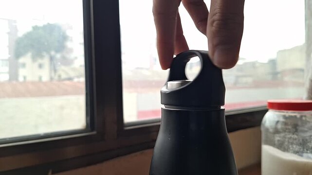Close-up of Hand Closing and Securing a Reusable Water Bottle Cap