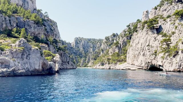 Calanque d'En-Vau bay seen from the sea with steep limestone cliffs, turquoise Mediterranean water and rocky coastline in Calanques National Park on the French Riviera, France.