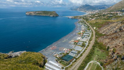 Obraz premium Aerial view of Fiuzzi beach, located on the Tyrrhenian coast of Calabria, in the province of Cosenza, Italy. It is a summer tourist destination. In the background is the Island of Dino, a tidal island
