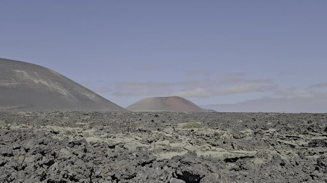 Rocky, barren landscape with an inactive volcano in the background on the island of Lanzarote. The scenery is lunar and futuristic. Horizontal video, fullHD