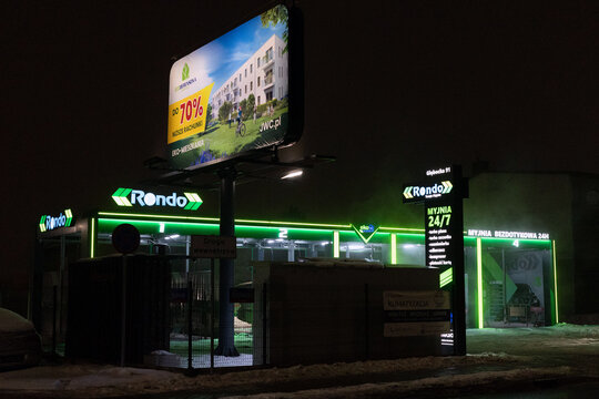 Warsaw, Masovian Voivodeship, Poland - January 28, 2026: A modern "Rondo" self-service car wash facility illuminated at night with vibrant neon green LED lighting