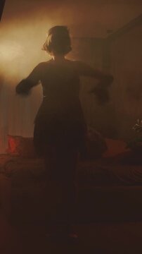 Old film style dark female silhouette dancing sexy vintage dress fringe waving. retro young happy woman dancer at night club party have fun. Charleston dance in night room full smoke vertical video.