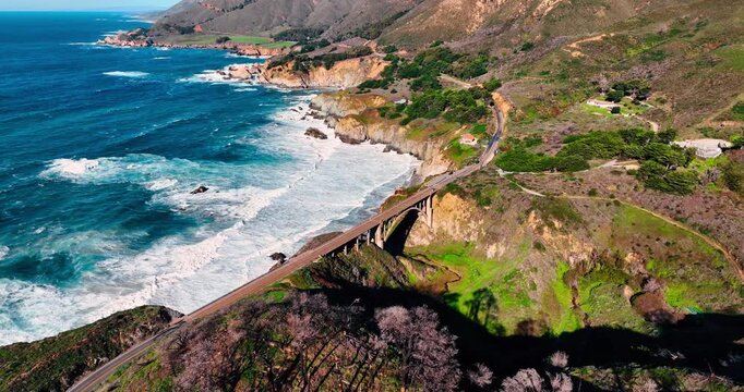 Scenic view on the fantastic rocky shore of Big Sur, California, USA. Approaching the stunning Bixby Bridge crossed by the cars.