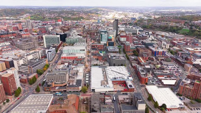 Aerial landscape drone footage above Sheffield city centre in South Yorkshire, UK with high street stores and cityscape skyline