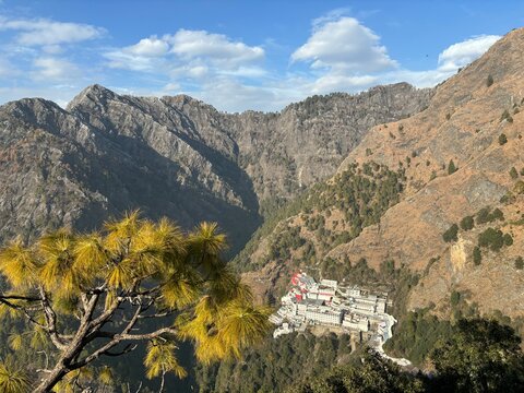 Pilgrimage journey to Vaishno Devi Temple featuring devotees walking the mountain trail through scenic hills and spiritual surroundings in Jammu and Kashmir.