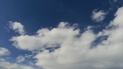Obraz premium Beautiful blue sky with fluffy white clouds on a bright sunny day