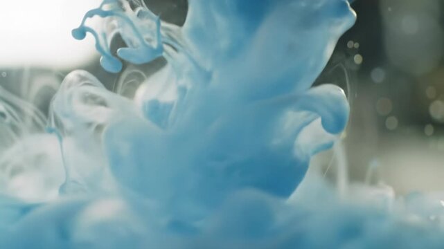Extreme macro video of translucent light blue and white inks slowly blending, forming ethereal marble patterns with softbox lighting, bokeh, and very slow push-in zoom, highlighting organic fluidity