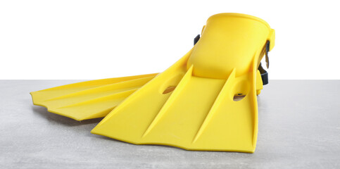Pair of yellow flippers on grey textured table isolated on white. Swimming accessories © New Africa