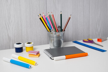 Art supplies on a table with colorful pencils, markers, and paper ready for drawing and crafting tasks in a creative space © Ms VectorPlus