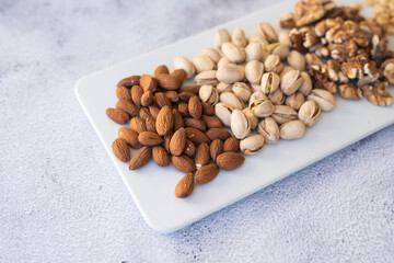 Almonds, pistachios, and walnuts arranged on a dining table, offering a nutritious and wholesome snack choice