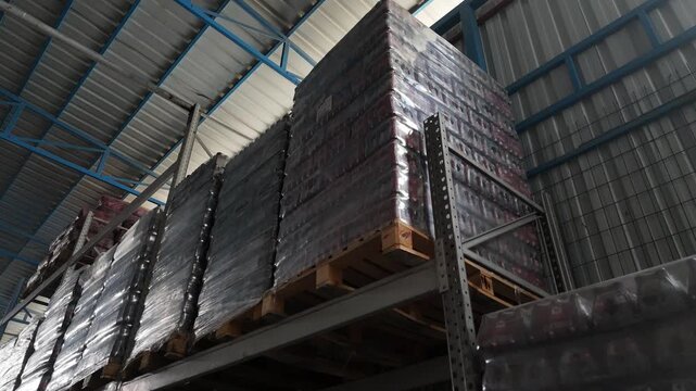 Warehouse interior or exterior showing storage facilities, shelves, pallets, and logistics operations. The video represents supply chain, inventory management, distribution, and industrial logistics, 