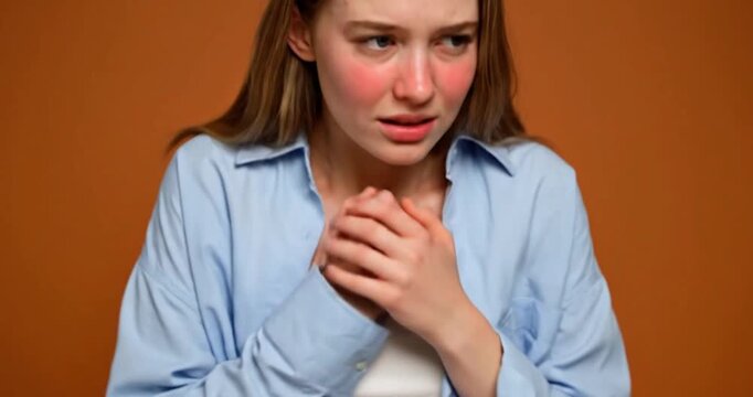Young Woman Showing Shyness and Social Self-Consciousness, Nervous Body Language in Studio Against Orange Background, 4K