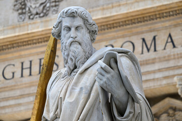 Obraz premium A statue of Saint Paul (by Adamo Tadolini, 1838) in front of Saint Peter's Basilica in the Vatican, Rome, Italy.