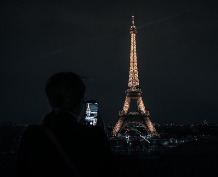 Paris, France: Eiffel tower in the night with tourist taking pictures