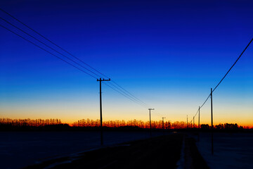 夜明け前の空と電柱のある風景
