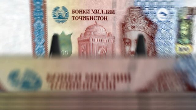 Tajikistan somoni Tajikistani money counting machine with banknotes. Quick 100 TJS currency note down rotation. Business and economy concept loopable and seamless background.