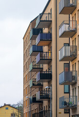 Obraz premium Modern apartment block with stacked balconies in soft daylight.
