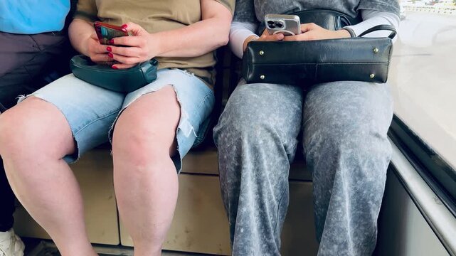 Three Seated Legs In Different Footwear On Subway Floor, Yellow Flipflops And Sneakers, Ripped Denim Hem And Gray Sweatpants, Casual Travel Vibe, Contrast Of Textures And Colors, Everyday.
