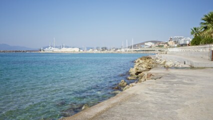 Obraz premium Coastal promenade and marina rendered in soft blurred shallow bokeh with visible quay and walkway outdoor; background copyspace calm.