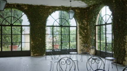 Naklejka premium Arched sunlit veranda with climbing ivy and wrought iron chairs, softly defocused with shallow bokeh garden; background backdrop copyspace calm.