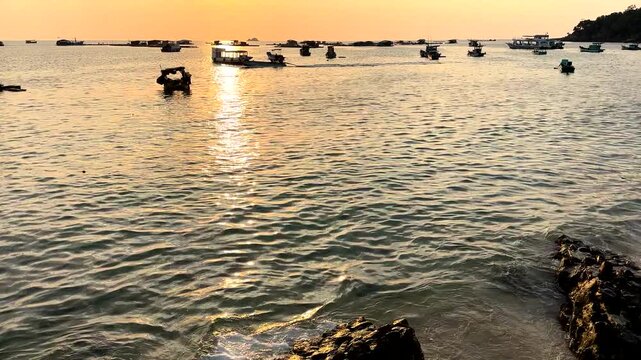 Boat moves in sea sunset. Marina with fishing boats at pier. Sunset marina with boats. Calm ocean at coast. Boat sails in sea at sunset. Fishing dock in sea on bright sunset in Vietnam. 