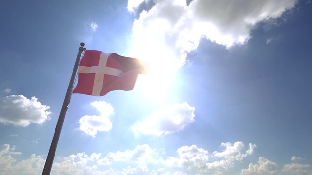 Denmark Flag waving on a Flagpole from a Moving Angle in front of a blue sky with clouds	