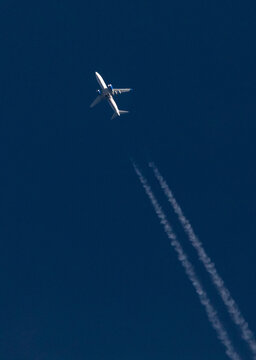 Commercial Airliner at High Altitude with Contrails