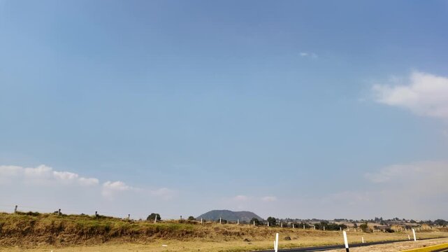 Paisaje de campo mexicano, viajes en carretera, cielo azul.