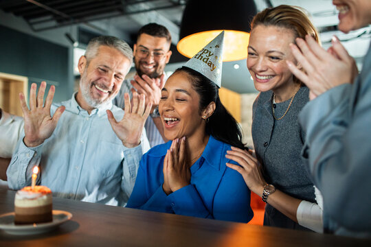 Coworkers celebrate a colleague's birthday in the office