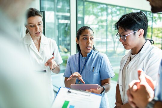 Medical team discussing patient case in hospital corridor