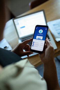Person using mobile banking app at home office desk
