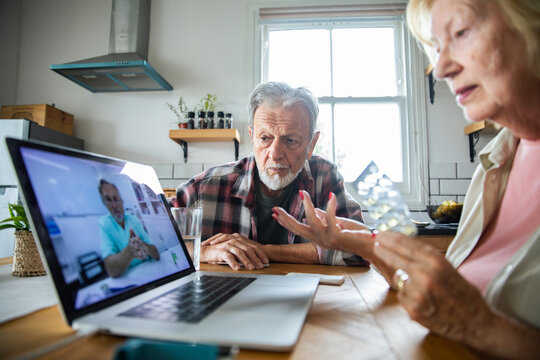 Senior couple consulting doctor about medication via telehealth at home
