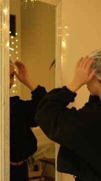 beautiful woman puts on a cosmetic disposable cap before the procedure. facial care, beauty salon, cosmetic procedures, facial massage, beauty salon. close-up, muted warm light