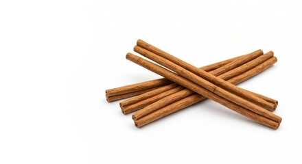 Close-up shot of several cinnamon sticks scattered against a plain white backdrop