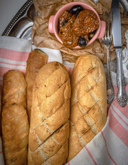 Fresh bread on rustic linen towel on table. Flat lay photography of artisanal bread baguettes on linen towel.