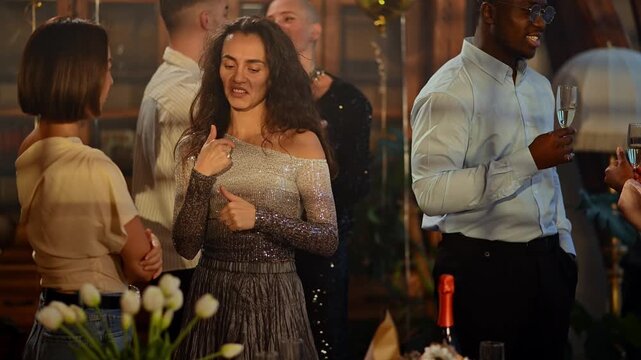 Diverse group of friends dancing and enjoying a lively conversation at an elegant evening cocktail party with champagne