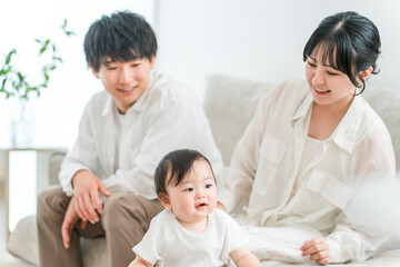 Fototapeta premium Smiling family with baby standing up using a table