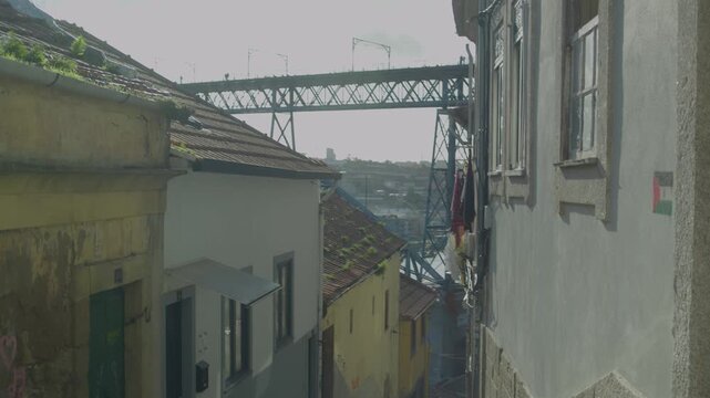 Historic street view with the iron structure of the Dom Luis I Bridge visible between buildings.
The bridge is an iconic symbol of Porto connecting the city to Vila Nova de Gaia.