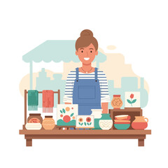 A smiling artisan stands behind a table displaying her handmade crafts at a market © PANGERANDESIGN