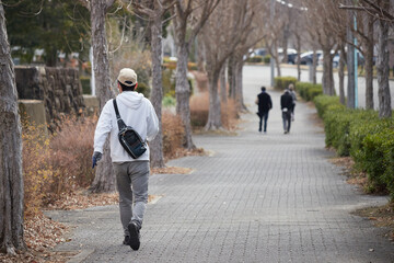 冬の公園でジョギングする人々の姿