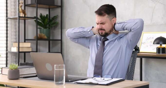 Man feeling fatigue at wooden desk in office