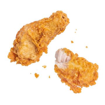 crispy golden fried chicken pieces, one drumstick and one thigh, breaking apart to reveal tender white meat
