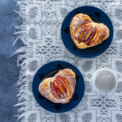 Two servings of homemade heart shaped peach pastries with powdered sugar.