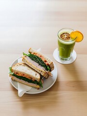 Artisan turkey sandwiches and a revitalizing green juice on a bright table