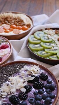 Vegan Breakfast Concept: Assorted Fruit Smoothie Bowls on a Rustic Wooden Table