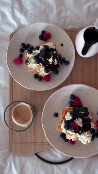 Delicious Homemade Waffles with Cream, Berries, and Chocolate Drizzle