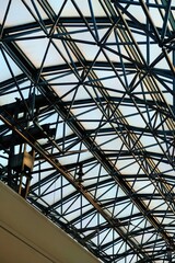 Fototapeta premium Geometric metal framework of a modern building's ceiling with translucent panels