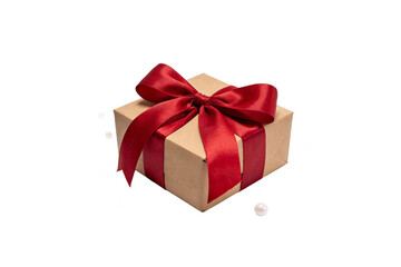 Fototapeta premium A brown gift box with a large red satin bow, adorned with small white pearls. Isolated on white background, suitable for festive gifting concepts.